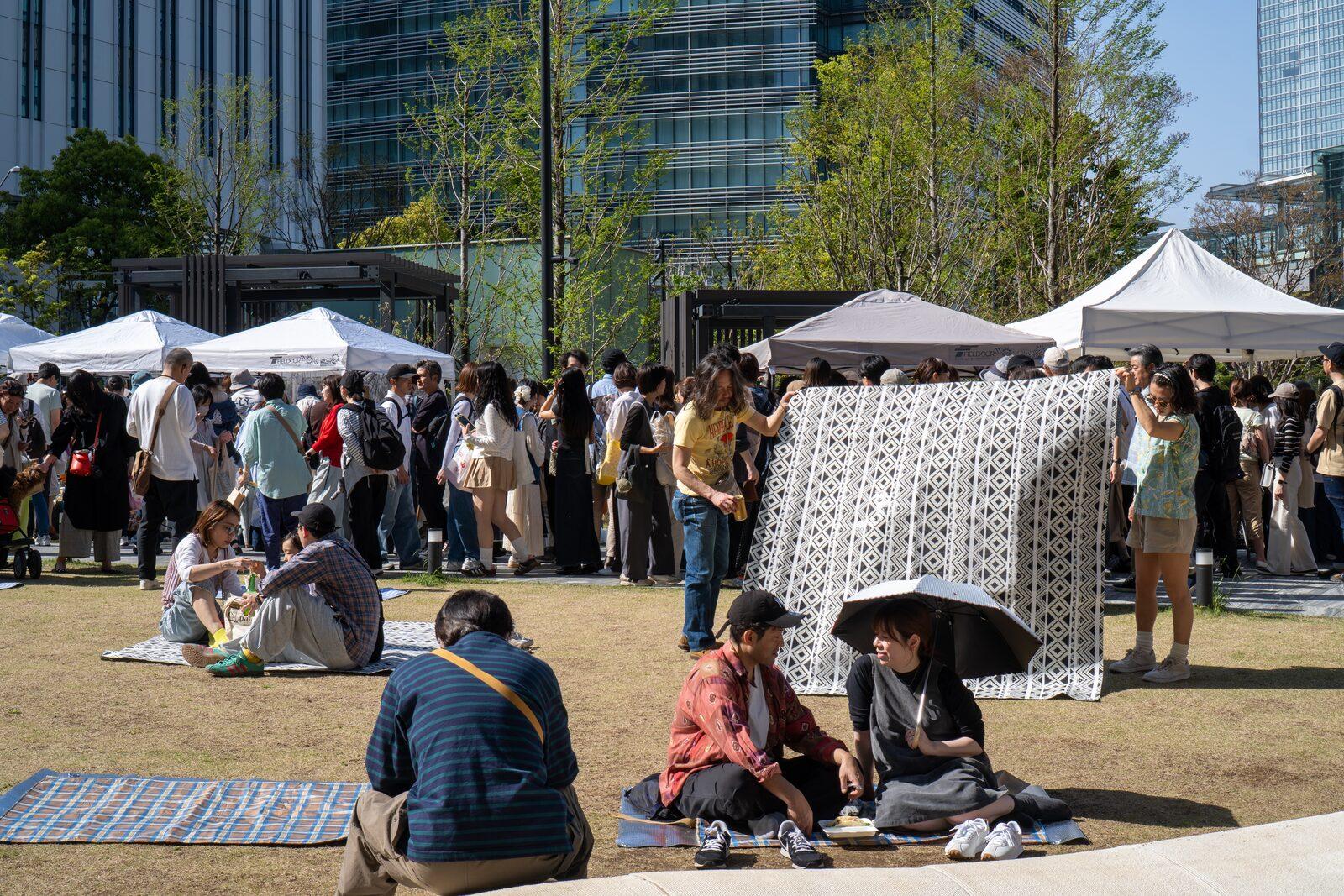 テントと来場者で賑わう会場と、みなとみらいの街並み
