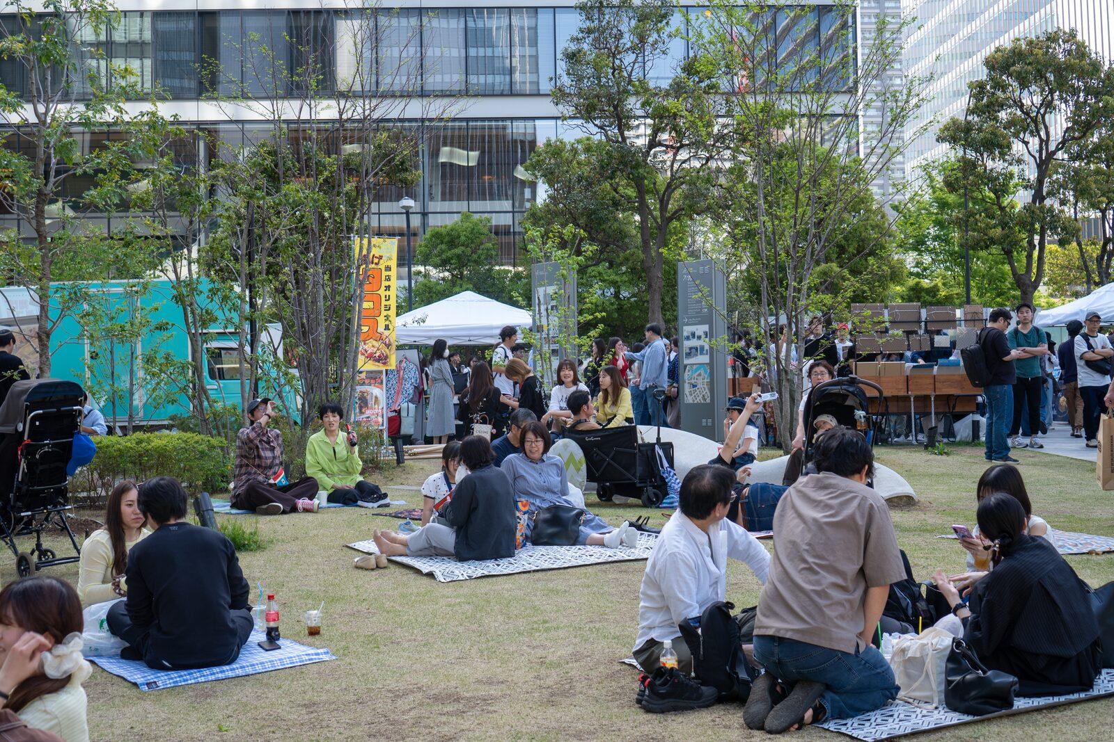 芝生広場でくつろぐ来場者